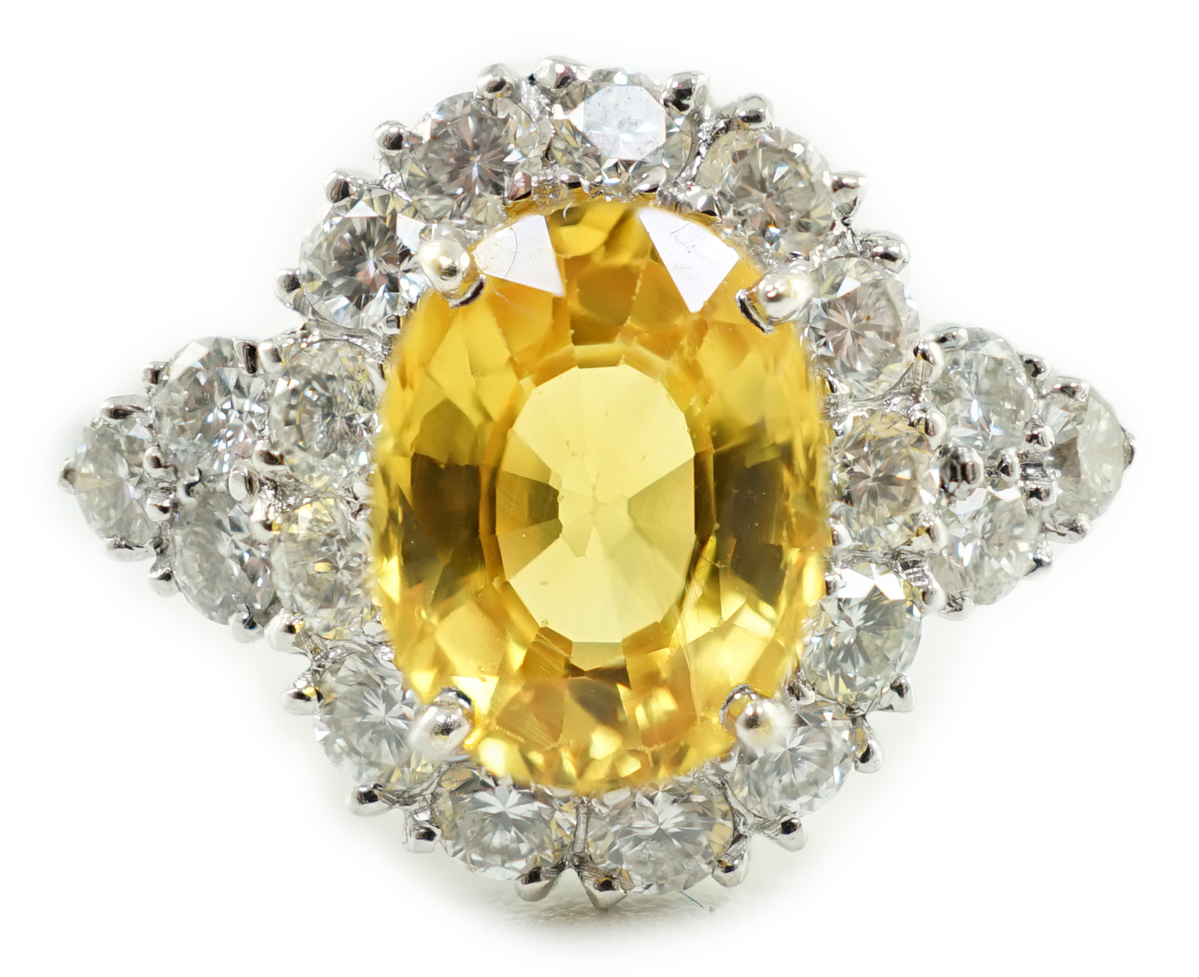 A modern 18ct white gold and single oval cut yellow sapphire set ring